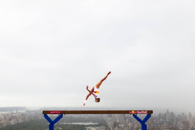 Thrill-seeking athlete Lily Smith has performed a daring balance beam routine 52 stories above street level.