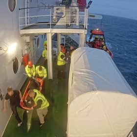 Crew members of CalMac's new MV Islay bring a man onboard after rescuing him in waters off the coast of Morocco.