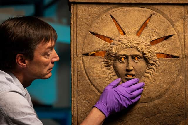 Curator Dr Fraser Hunter examines the Roman altars. Picture: Duncan McGlynn