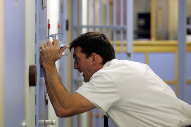 A police officer speaks to a detained man in the cells (Picture: Matt Cardy)