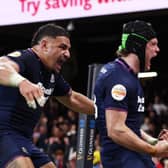Darcy Graham of Scotland celebrates scoring his team's third try against Wales with teammate Sione Tuipulotu.