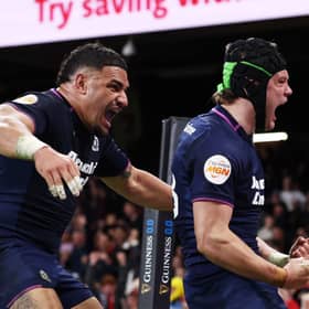Darcy Graham of Scotland celebrates scoring his team's third try against Wales with teammate Sione Tuipulotu.