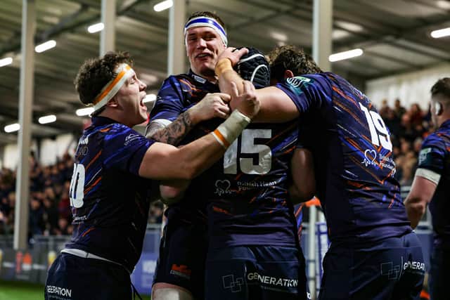 Harry Paterson is mobbed by his Edinburgh teammates after scoring the winning try.