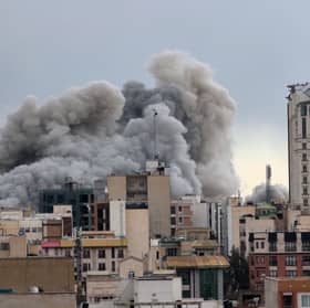 A plume of smoke rises after a strike in Tehran on Monday