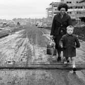 Norma Dickson and her son walk through a muddy Muirhouse street in November 1964.