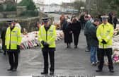 Policemen and members of the community observe a one-minute silence at  Dunblane Primary School after the 1996 shooting tragedy 