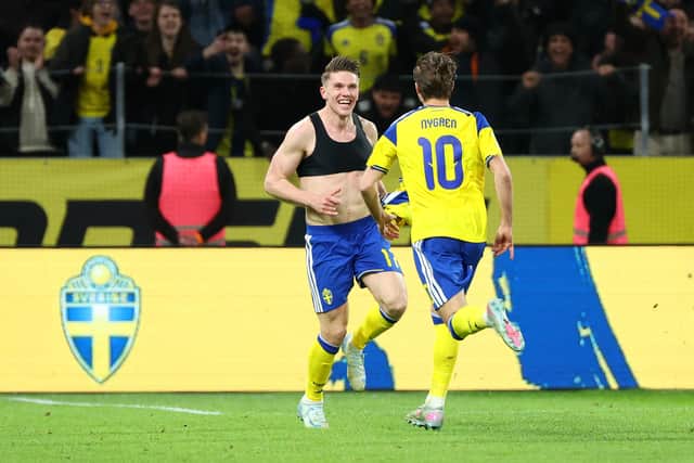 Benjamin Nygren rushes to celebrate with Viktor Gykores after Sweden defeated Poland to reach the World Cup.