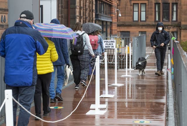 People queue to vote in the 2021 Scottish Parliament election outside the polling station at Notre Dame Primary School in Glasgow