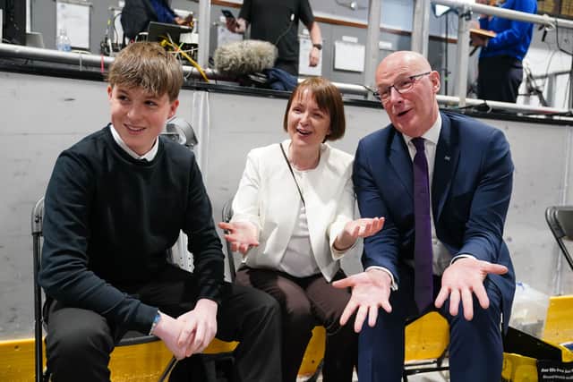 First Minister and SNP leader John Swinney sits with his wife Elizabeth and son Matthew, at the counting centre for the 2026 Holyrood elections, at Dewars Centre in Perth.