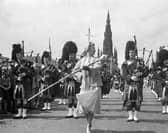 American actress Vera-Ellen leads a pipe band in Princes Street whilst filming the 1956 movie Let's Be Happy.