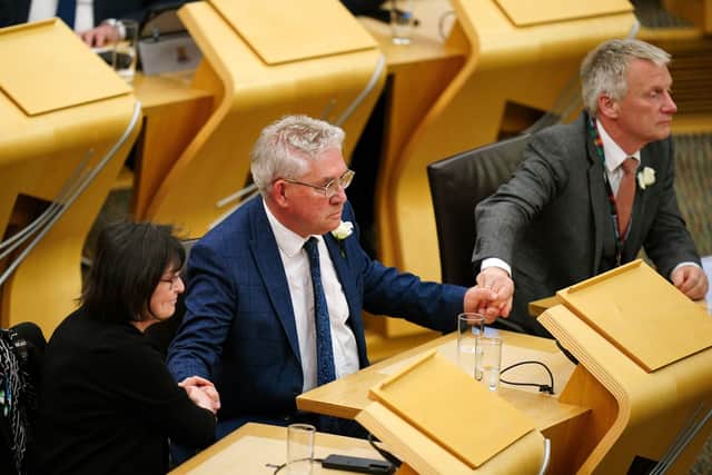Kenny Gibson holds his colleagues hands as he is announced as the new presiding officer.