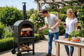 The portable outdoor pizza oven bundle includes a pizza stone, peel, cutter and integrated thermometer for garden cooking