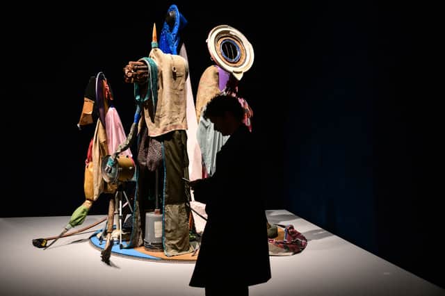 A visitor looks at Centinelas de la luna nueva by Afro-Puerto Rican artist Daniel Lind-Ramos at the exhibition In Minor Keys, during the pre-opening press view of the 61st Venice Biennale