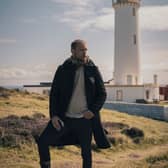 Sam Heughan with a hip flask of his Sassenach Spirits, at the Mull of Galloway Lighthouse.