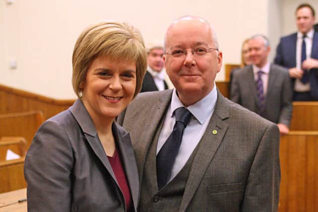 SNP leader Nicola Sturgeon poses with husband Peter Murrell and her seal of office after being formally sworn in as Scotland's first minister at the Court of Session in Edinburgh on November 20, 2014.