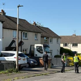 Police officers at the scene where a lorry has crashed into a house on Brand Drive, Edinburgh. 