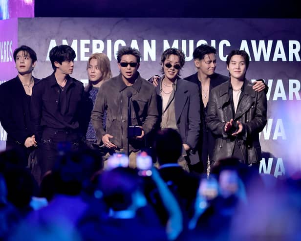 Jungkook, Jin, Jimin, RM, J-Hope, V and Suga of BTS accept the Artist of the Year award onstage during the 52nd American Music Awards.