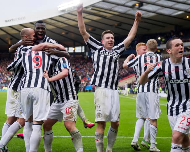 John McGinn, right, celebrates winning the 2013 League Cup final alongside St Mirren team-mate Paul Dummett, centre with arms raised.