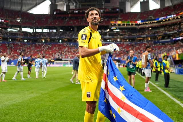 Vozinha holds a Cape Verde flag after the draw with Spain.