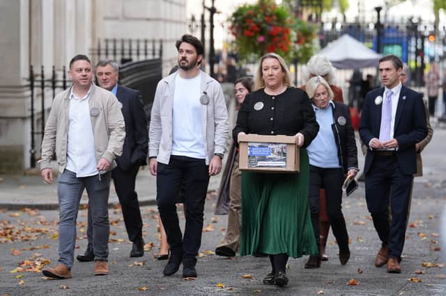 Family members of victims of the 1994 RAF Chinook crash arrive carrying a petition to hand in to 10 Downing Street, London, in October 2025, as they demand answers over what happened