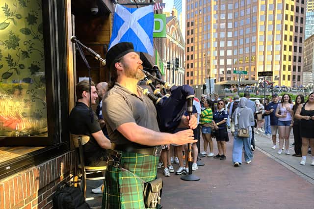 Matt McArthur playing the bagpipes outside the While Bull Tavern in Boston