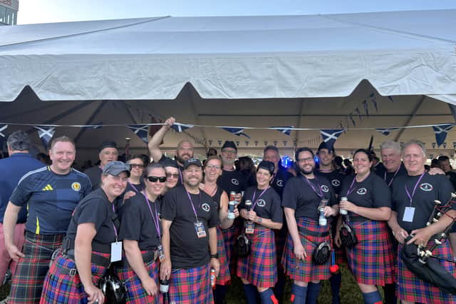 Members of the Rhode Island Highlanders Pipe Band and one Scotland fan