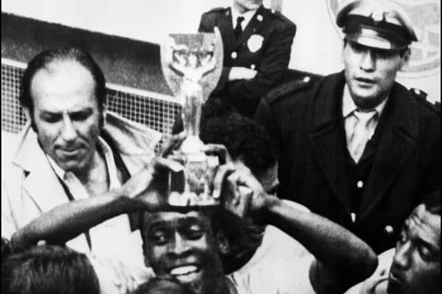 Brazilian forward PelT smiles as he holds aloft the Jules Rimet Cup after Brazil beat Italy 4-1 in the World Cup final 21 June 1970 in Mexico City.