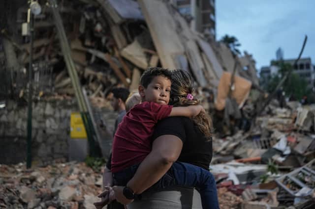 People walk past a collapsed building in Caracas (Picture: Manaure Quintero)