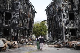 Two people look at burned-out buildings in Caracas after the area was hit by two major earthquakes in quick succession (Picture: Jesus Vargas)