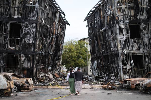 Two people look at burned-out buildings in Caracas after the area was hit by two major earthquakes in quick succession (Picture: Jesus Vargas)
