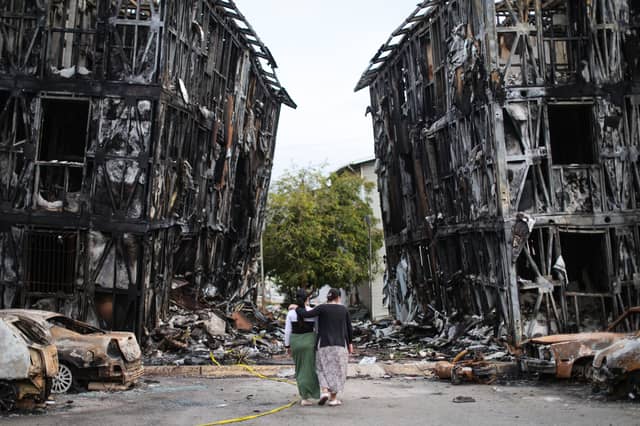 Two people look at burned-out buildings in Caracas after the area was hit by two major earthquakes in quick succession (Picture: Jesus Vargas)