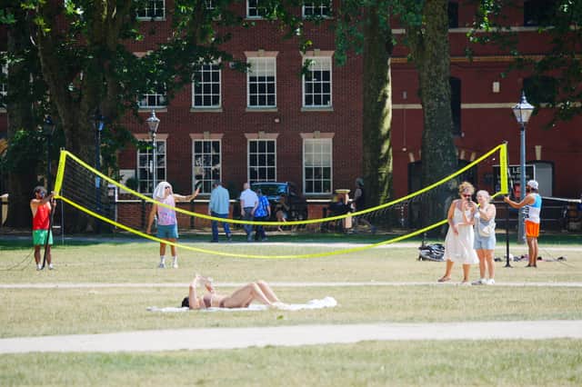 People enjoying the warm weather in Queen Square, Bristol