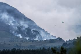A helicopter carrying water tackles the wildfire burning near Nethy Bridge in Cairngorms National Park in north-east Scotland (Jane Barlow/PA)