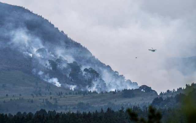 A helicopter carrying water tackles the wildfire burning near Nethy Bridge in Cairngorms National Park in north-east Scotland (Jane Barlow/PA)