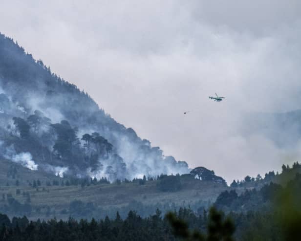 A helicopter carrying water tackles the wildfire burning near Nethy Bridge in Cairngorms National Park in north-east Scotland (Jane Barlow/PA)