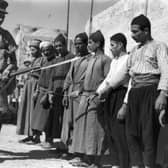 A soldier guards Arab prisoners in the Old City of Jerusalem in 1938, during the British mandate in Palestine (Picture: Fox Photos)