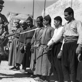 A soldier guards Arab prisoners in the Old City of Jerusalem in 1938, during the British mandate in Palestine (Picture: Fox Photos)