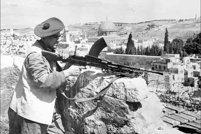 A soldier stands guard with a Bren gun at the demarcation line between Jewish and Arab quarters in Jerusalem in 1948, as the British Mandate nears its end