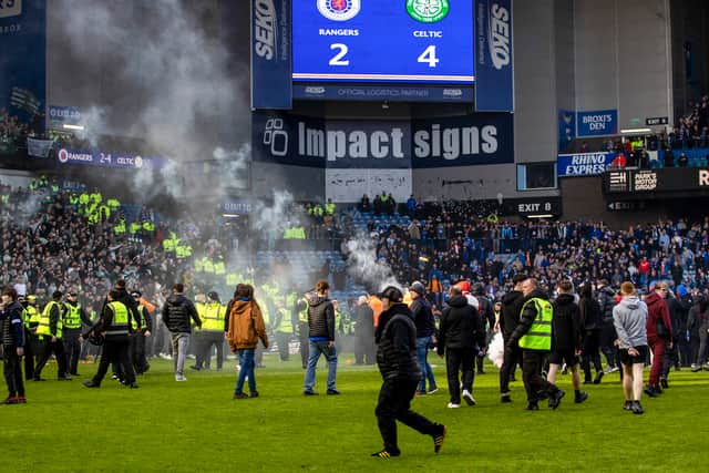 Rangers and Celtic fans storm on to the pitch during the March 8 derby at Ibrox.
