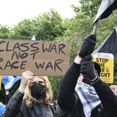A campaigner holds up a placard stating 'Class War Not Race War' at Glasgow Green.