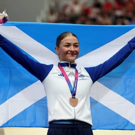  Bronze medalist Erin Boothman of Team Scotland poses with her flag on the podium during the Women's 4000M Individual Pursuit 
