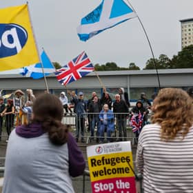 A police officer stands between groups of rival protesters outside the Cladhan Hotel in Falkirk (Picture: Jeff J Mitchell)