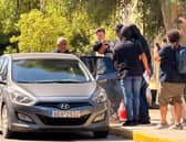 The suspect, widely reported to be Sharif Ahmadzai (centre), being led out of the Athens Court House complex in Kypseli, Athens, where he appeared accused of killing 38-year-old Elisabeth-Jane Ross and disposing of her body in a suitcase.   