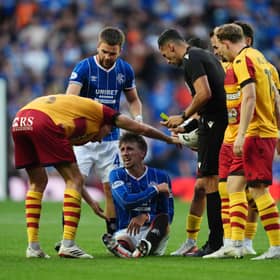 Rangers' Dan Neil sits injured after a foul by Jagiellonia Bialystock's Taras Romanchuk 