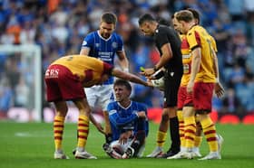 Rangers' Dan Neil sits injured after a foul by Jagiellonia Bialystock's Taras Romanchuk 