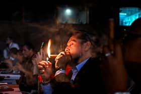 A smoker lights his cigar during the Cigar Festival at the Convention Palace in Havana, Cuba (Picture: Yamil Lage)          