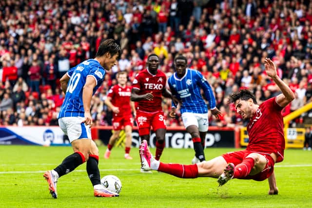 Kim Min-su dribbles past Dan Happe during a promising Rangers debut against Aberdeen.