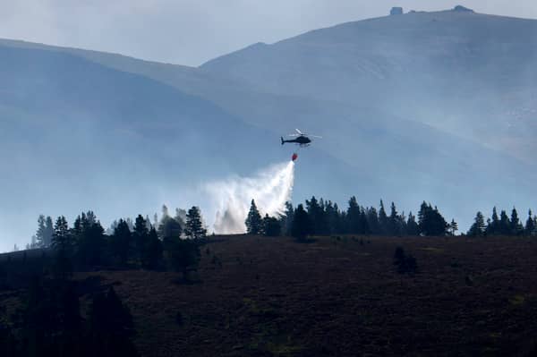 A helicopter drops water on the Cairngorm wildfire in July (Picture: Jeff J Mitchell)