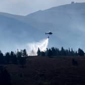 A helicopter drops water on the Cairngorm wildfire in July (Picture: Jeff J Mitchell)
