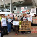 Protesters against data centres holding banners and placards, outside the Scottish Parliament